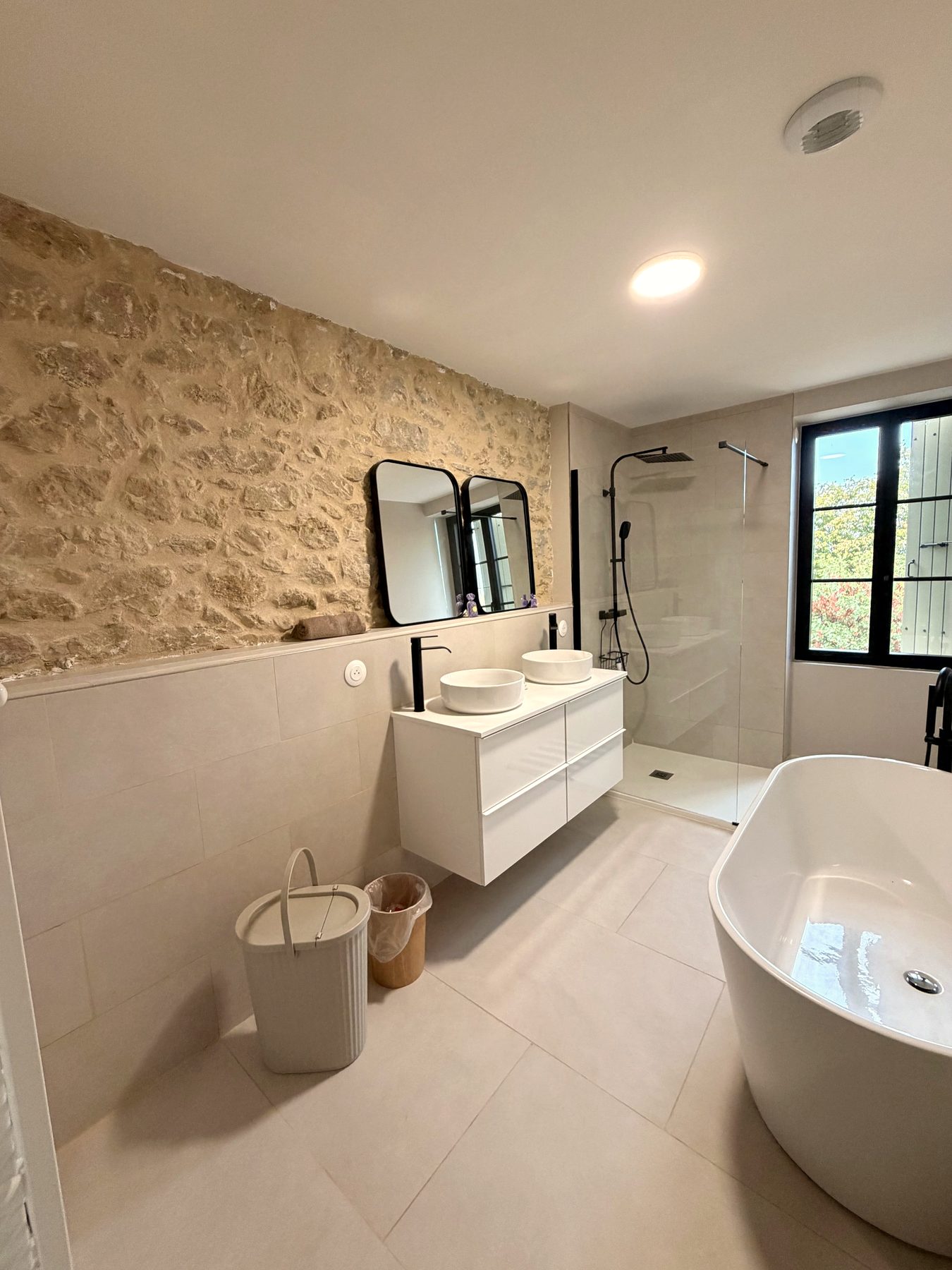 Badkamer met vrijstaand bad, regendouche en natuursteen